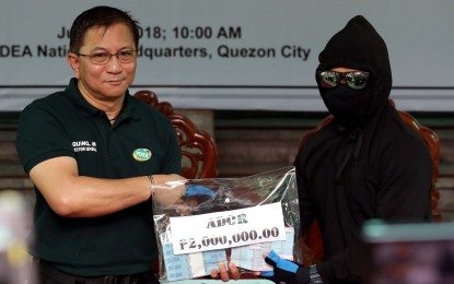 <p><strong>REWARD FOR INFORMANTS.</strong> Philippine Drug Enforcement Agency (PDEA) Director General Aaron Aquino hands over the PHP2-million cash reward to informant "Ador" in a ceremony at the PDEA headquarters in Quezon City on Tuesday (June 26, 2018). The move is in line with the program known as Operation: "Private Eye", a reward and incentive scheme designed to encourage private citizens to report any suspected illegal drug activities in their community. <em>(PNA photo by Joey O. Razon)</em></p>